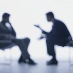 Blurry silhouettes of two people conversing