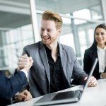 Smiling business colleagues shaking hands at meeting