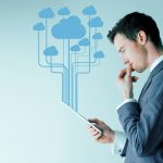 Businessman using tablet with cloud computing icons