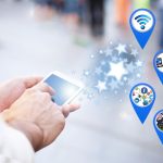 Hand holding smartphone with IoT connectivity icons